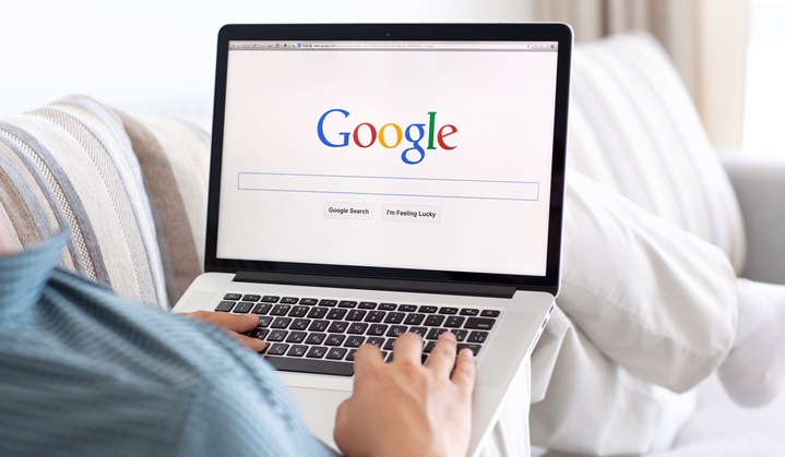 man sitting on couch searching on google